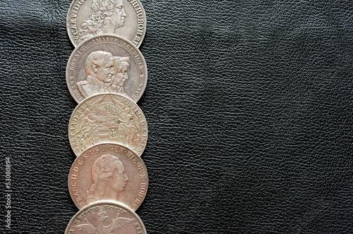 Photo: Ancient silver coins on a leather surface Ancient silver coins on a leather surface