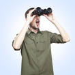 young man looking through binoculars, surprise face expression