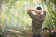 young man enjoying sunlight in a green summer forest