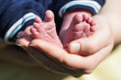 Babyfüße in der Hand der Mutter