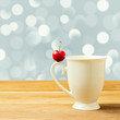 Single cherry on cup handle over bokeh background