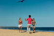 Photo: Man and women running on beach with kite Man and women running on beach with kite