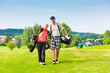 Photo: Young sportive couple playing golf on a course Young sportive couple playing golf on a course