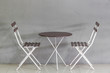 Small table and chairs near grunge wall