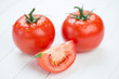 Photo: Ripe red tomatoes and their segment on wooden boards Ripe red tomatoes and their segment on wooden boards