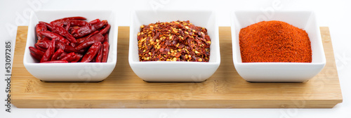 Photo: Whole chili peppers, flakes, and chili powder isolated on white Whole chili peppers, flakes, and chili powder isolated on white