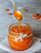 Jar of apricot fruit jam with almonds