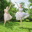 Two young happy beautiful women running on grass