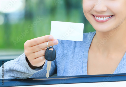 Photo: girl in a car showing a key and an empty white card girl in a car showing a key and an empty white card