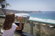Young Girl Looking Out Over the Pacific Ocean with Telescope
