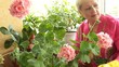 Mature woman caring for flowers in pots