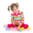 Photo: child girl playing with construction set over white background child girl playing with construction set over white background
