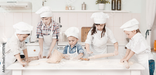 Photo: happy little chefs preparing dough in the kitchen with their happy little chefs preparing dough in the kitchen with their