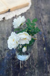 Dog rose flowers in a glass on rusted wooden table