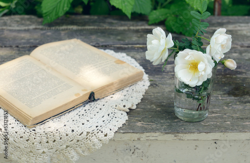 Photo: Dog rose flowers in a glass on rusted wooden table Dog rose flowers in a glass on rusted wooden table
