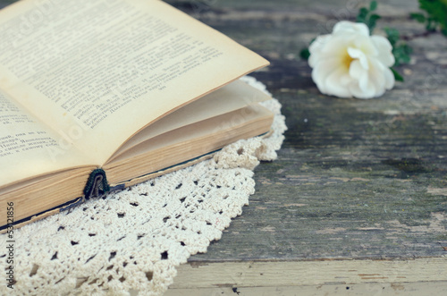 Photo: Open book on lace doily on rusted garden table Open book on lace doily on rusted garden table