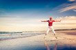 Senior woman enjoying beach holiday jumping in air