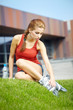 Woman skating in city. Girl going rollerblading sitting in grass