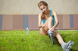 Woman skating in city. Girl going rollerblading sitting in grass