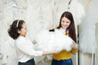 Foto: Two happy women chooses bridal outfit Two happy women chooses bridal outfit