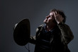 A man holding a cowboy hat and looking up thoughtfully.