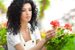 Female gardener in a greenhouse analyzing some flowers