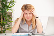 woman with headache sitting at the table