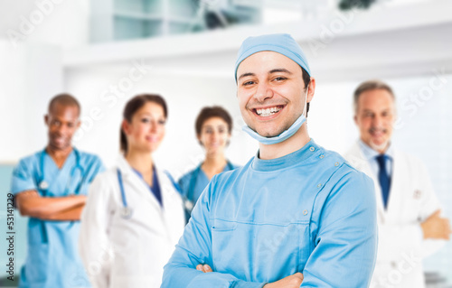 Photo: Smiling doctor in front of his team Smiling doctor in front of his team