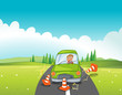 A boy in a green car bumping the traffic cones