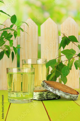 Photo: Glasses of birch sap on green wooden table Glasses of birch sap on green wooden table
