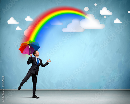 Photo: Businessman with umbrella atop of building Businessman with umbrella atop of building