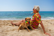 man laying with dog at the beach