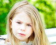 Adorable blond crying little girl with tears on her cheeks