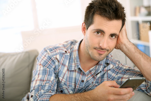Photo: Handsome man using smartphone at home Handsome man using smartphone at home