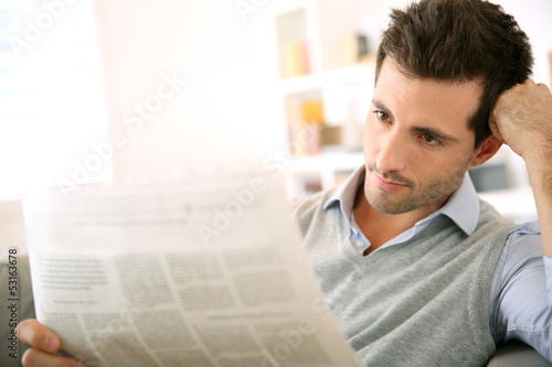 Photo: Man at home reading newspaper Man at home reading newspaper