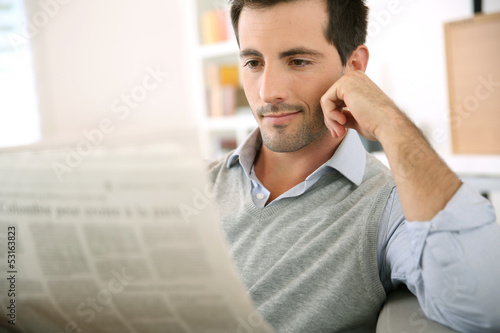 Photo: Man at home reading newspaper Man at home reading newspaper