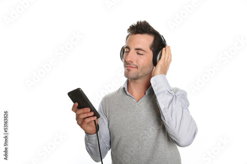 Photo: Man relaxing with headset and music player Man relaxing with headset and music player