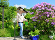 Frau im Garten mit Rhododendron