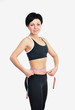 Young fitness woman measuring her waist