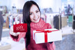 Photo: Attractive female shopper show gift card and box Attractive female shopper show gift card and box