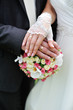 Hands and rings on wedding bouquet