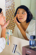 Asian woman discovering a pimple in face