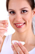 Young woman putting contact lens in her eye close up