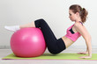Portrait of beautiful young woman exercises with gym ball
