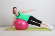 Portrait of beautiful young woman exercises with gym ball