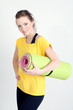 Portrait of beautiful young woman with gym mat
