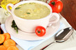 Nourishing soup in pink pan on wooden table close-up