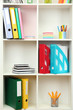 White office shelves with different stationery, close up