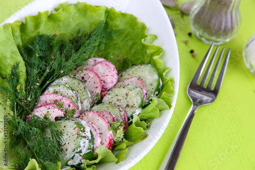 Photo: Vitamin vegetable salad in bowl on wooden table close-up Vitamin vegetable salad in bowl on wooden table close-up