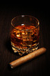 Brandy glass with ice on wooden background